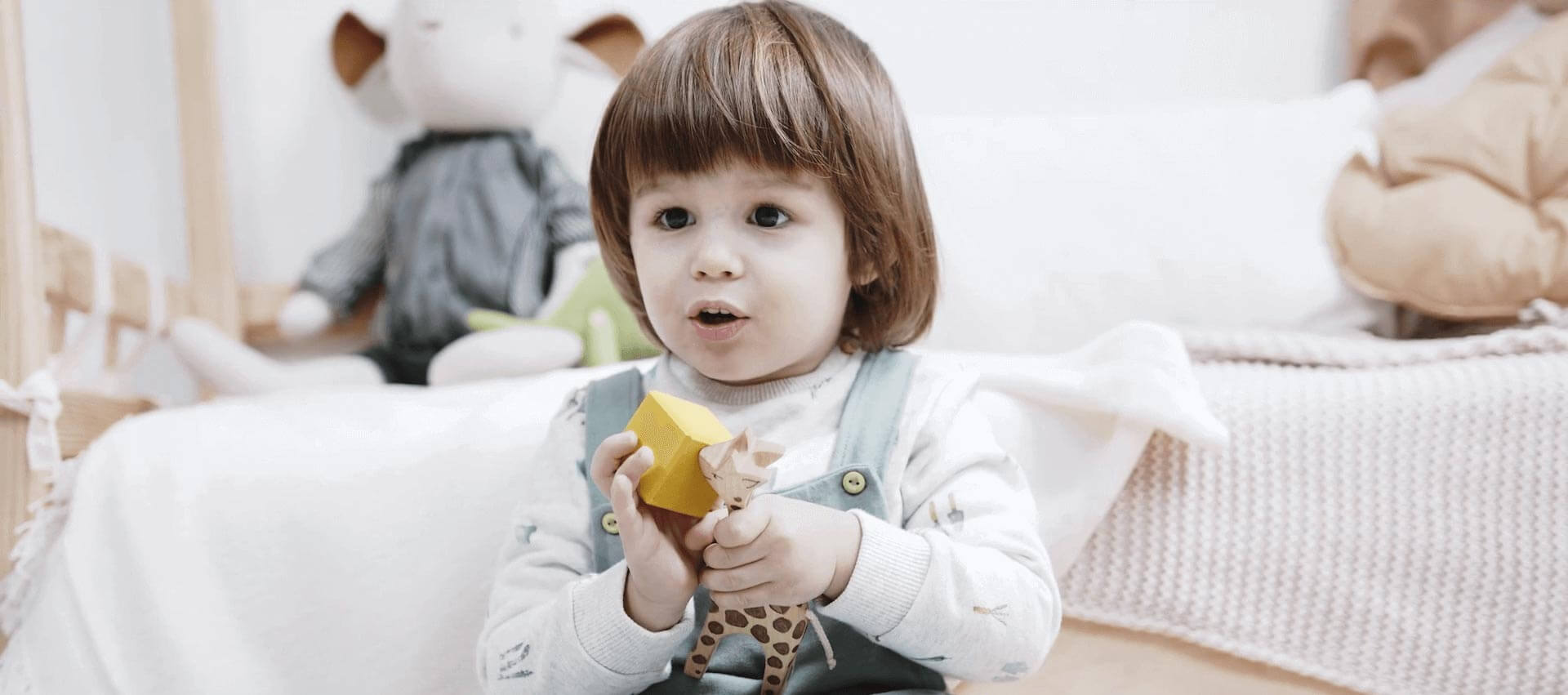 Young child sitting with a plush toy