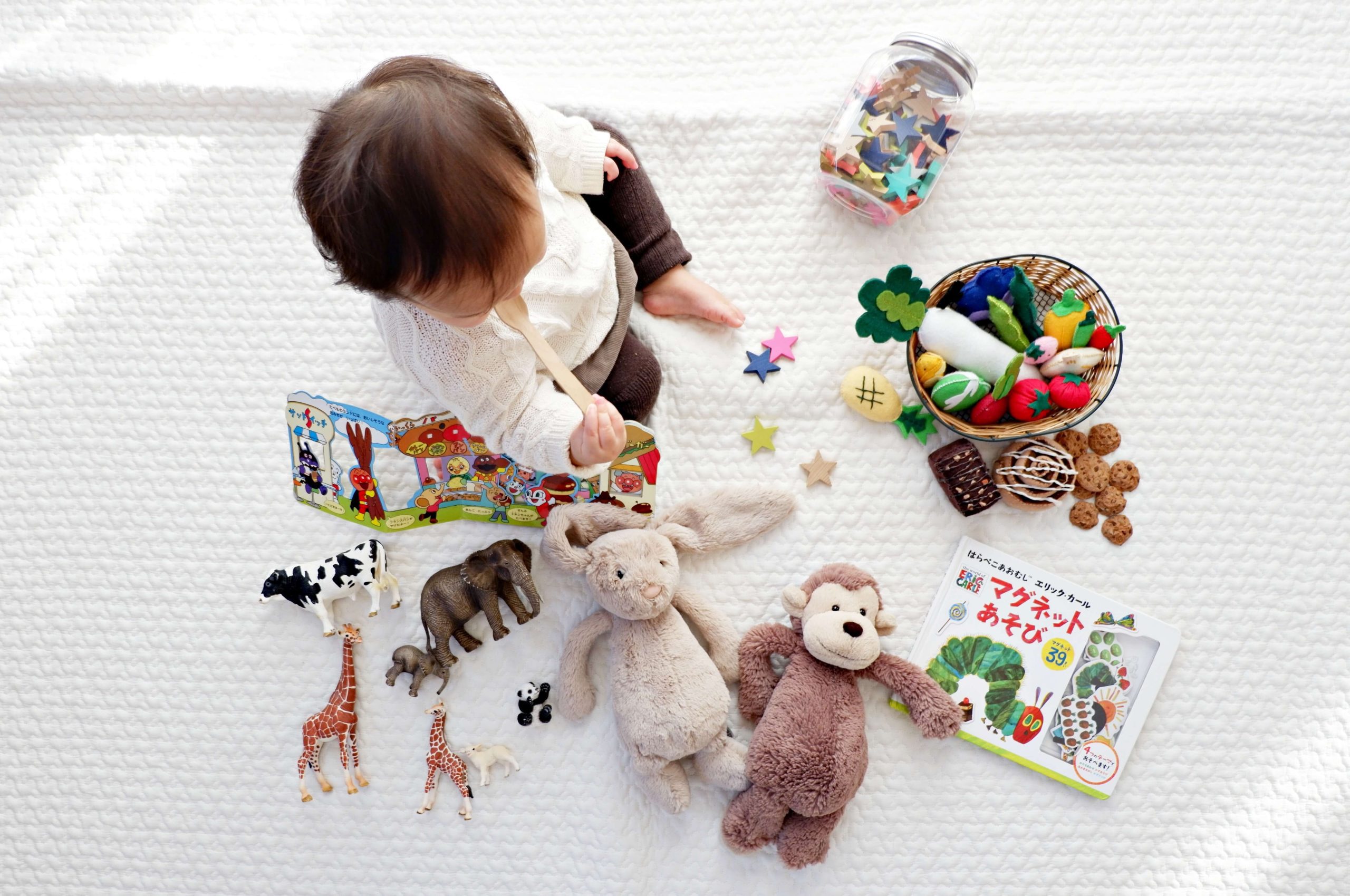 Child playing with toys and books on a rug