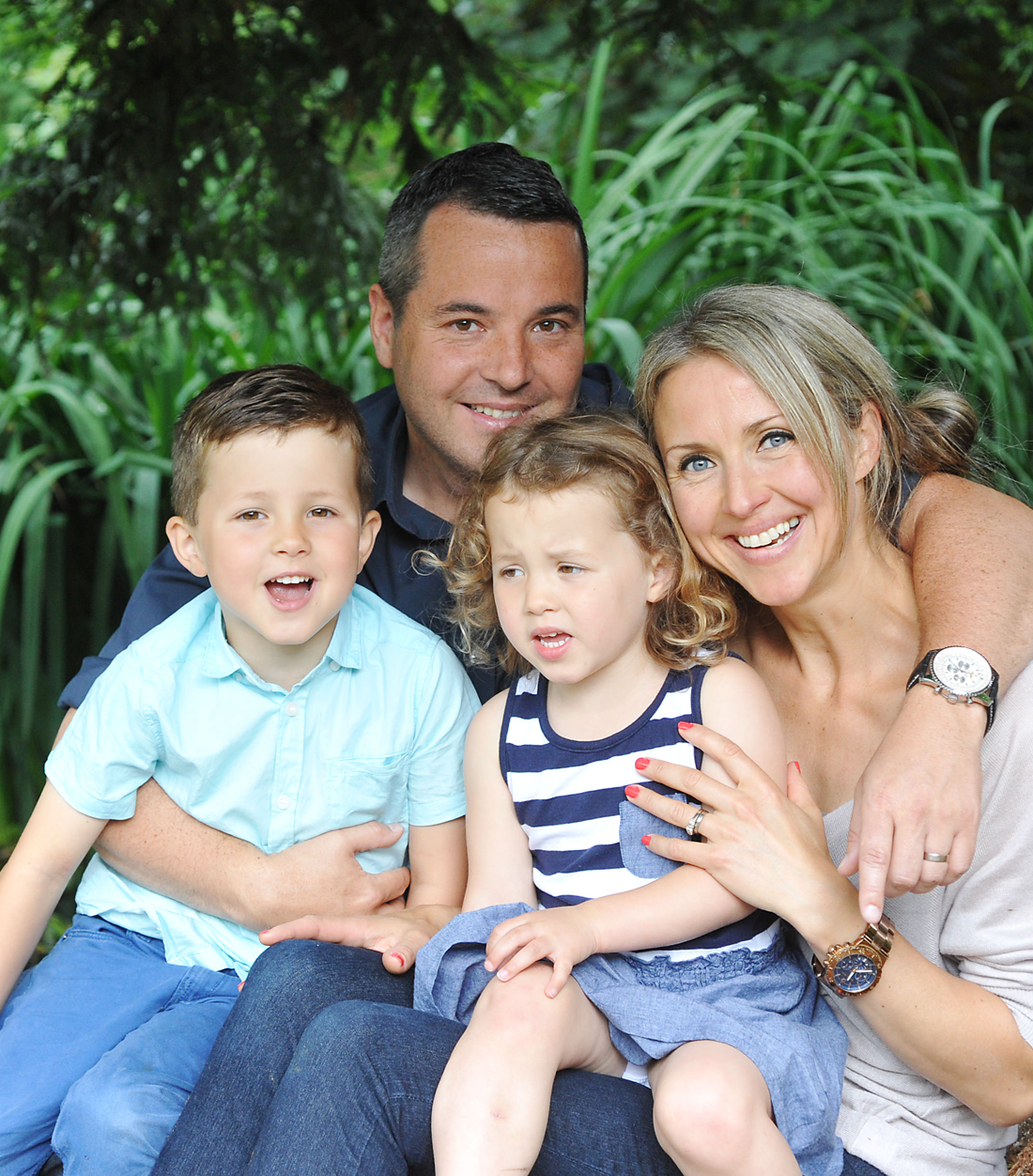 Family of four smiling outdoors